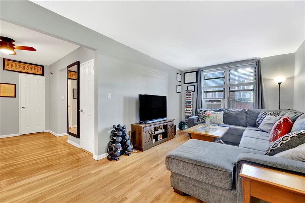 7259 Shore Road, Unit 2G Brooklyn, NY 11209 - Photo 6 of 16 a living room with furniture and a flat screen tv