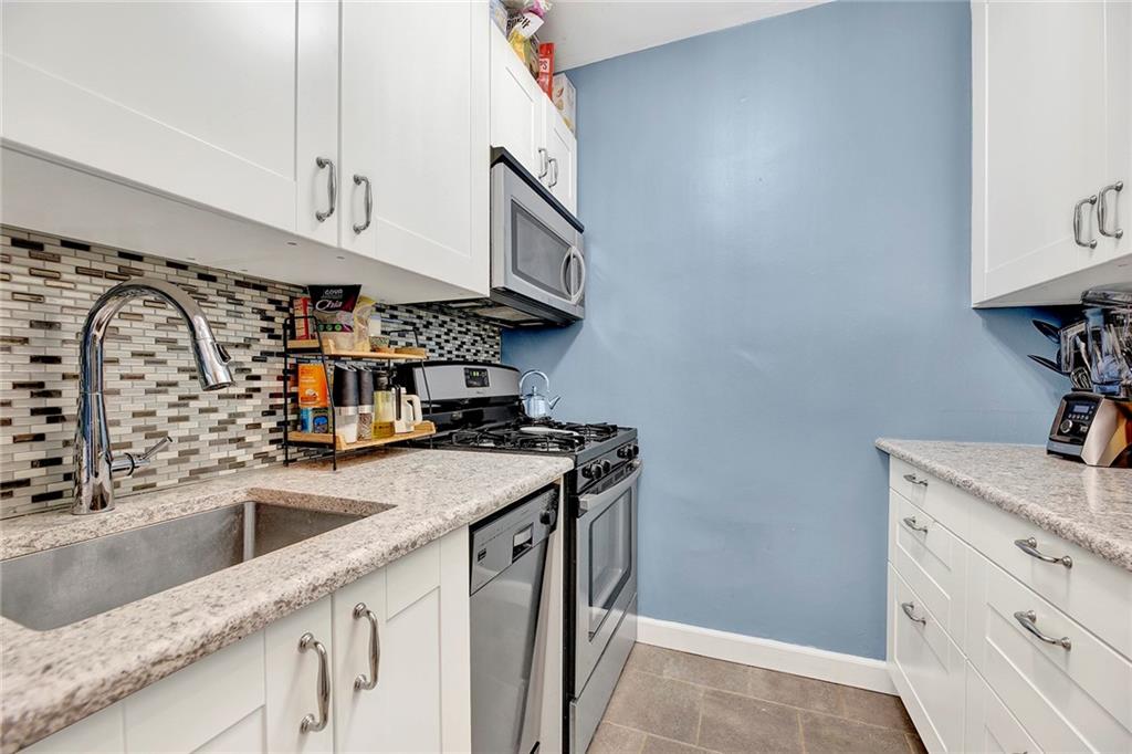 7259 Shore Road, Unit 2G Brooklyn, NY 11209 - Photo 9 of 16 a kitchen with stainless steel appliances granite countertop a sink stove and cabinets