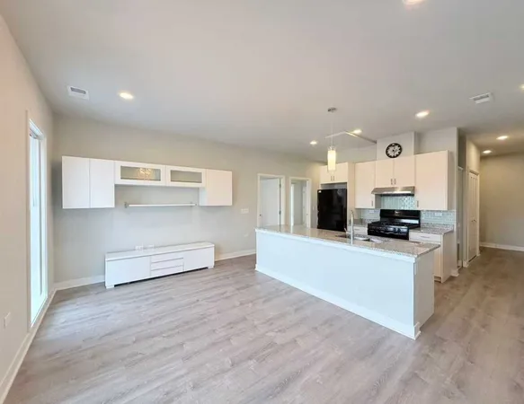 a large kitchen with stainless steel appliances granite countertop a stove and a sink