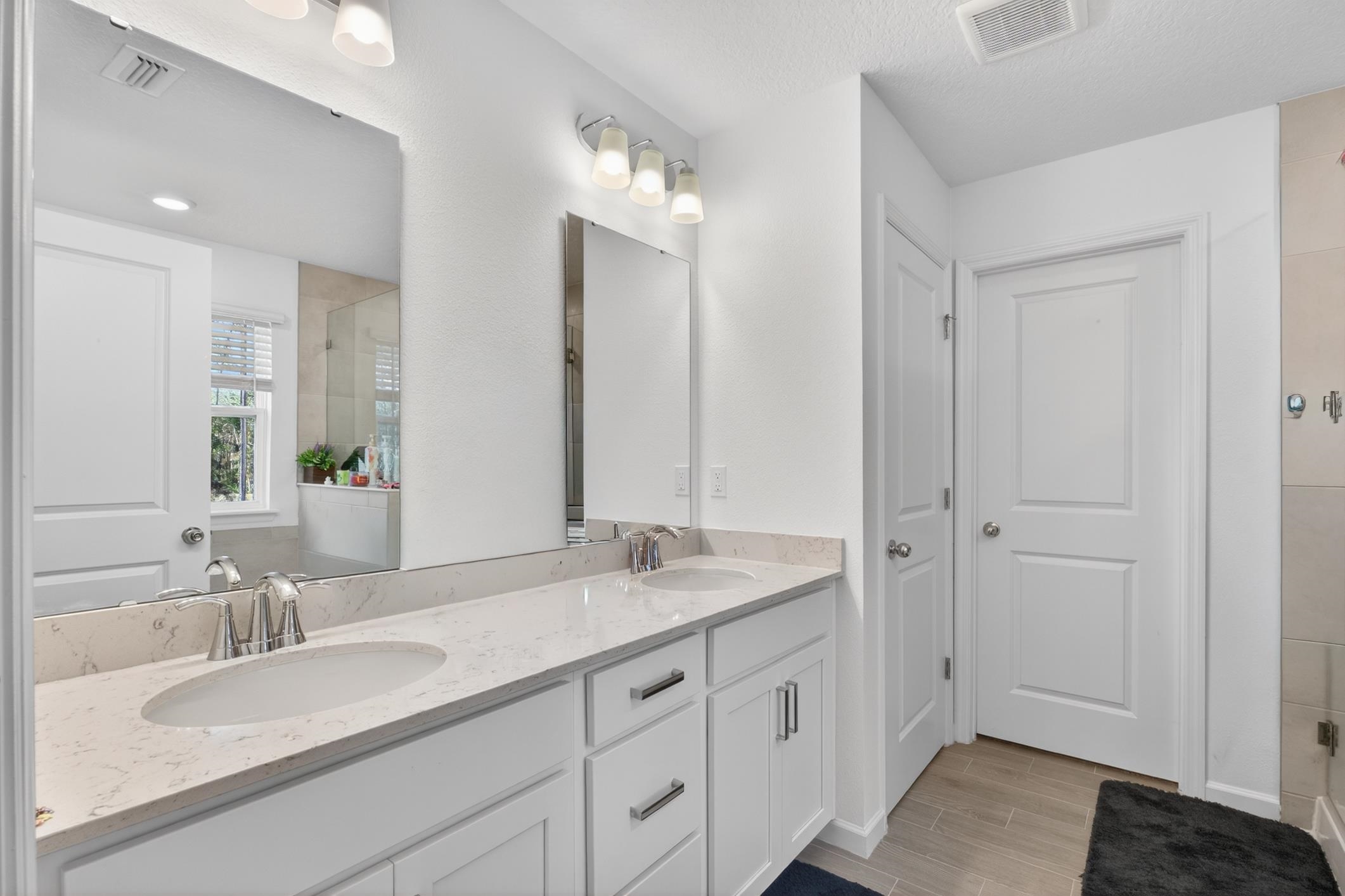 177 White Rabbit Run St. Augustine, FL 32092 - Photo 27 of 51 Bathroom featuring double vanity, an enclosed shower, wood tiled floors, and a textured ceiling