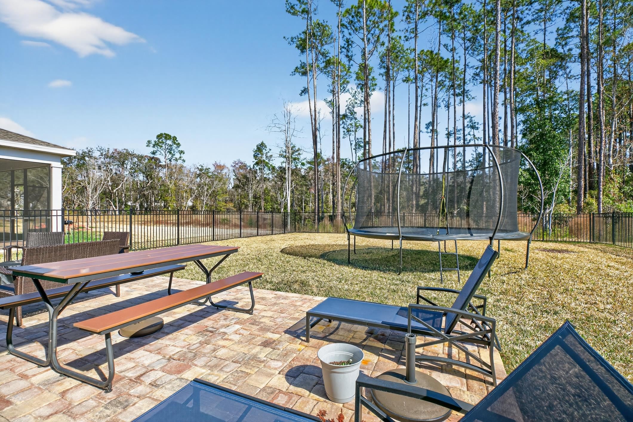 177 White Rabbit Run St. Augustine, FL 32092 - Photo 42 of 51 Fenced backyard featuring a patio area, a trampoline, outdoor dining space, and a sunroom