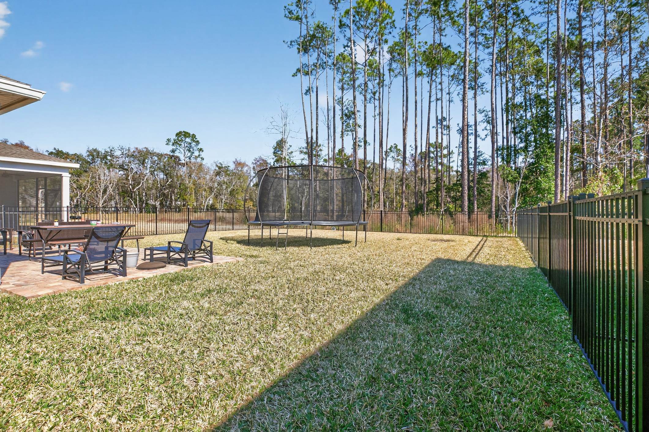 177 White Rabbit Run St. Augustine, FL 32092 - Photo 48 of 53 Fenced backyard with a trampoline, a patio, and a sunroom