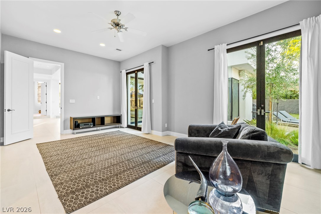 2000 Grouse Street Las Vegas, NV 89134 - Photo 13 of 89 A living space with recessed lighting and a ceiling fan opens to an outdoor patio through glass doors.