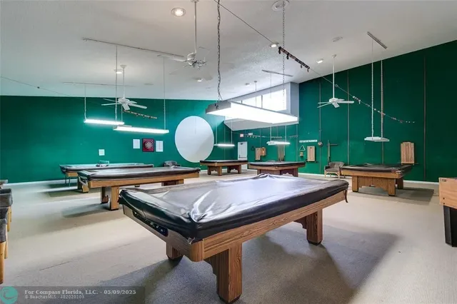 a room with furniture pool table and fan
