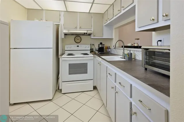 a kitchen with appliances a sink and cabinets