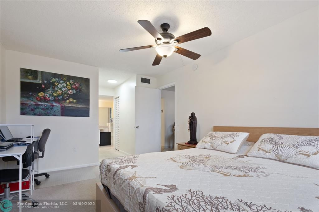 9400 Lime Bay Boulevard, Unit 214 Tamarac, FL 33321 - Photo 7 of 17 a bedroom with a large bed and a chandelier