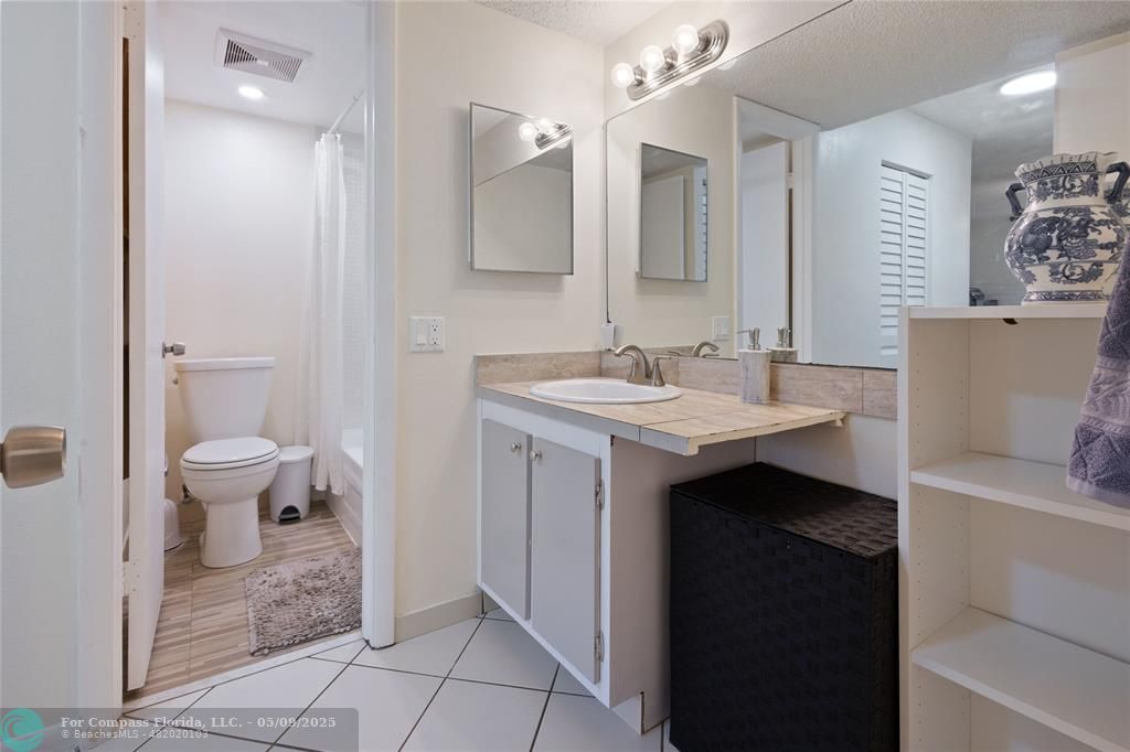 9400 Lime Bay Boulevard, Unit 214 Tamarac, FL 33321 - Photo 9 of 17 a bathroom with a sink a toilet and a mirror