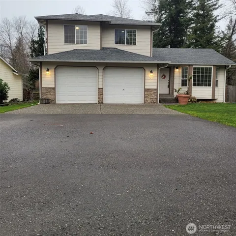a front view of a house with a garden and garage