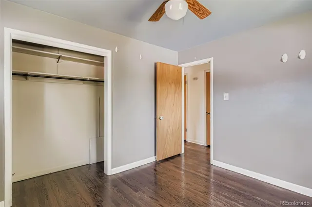 a view of an empty room with wooden floor and closet