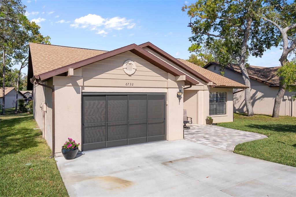6732 Oak Cluster Circle Spring Hill, FL 34606 - Photo 2 of 65 a front view of a house with a yard and garage
