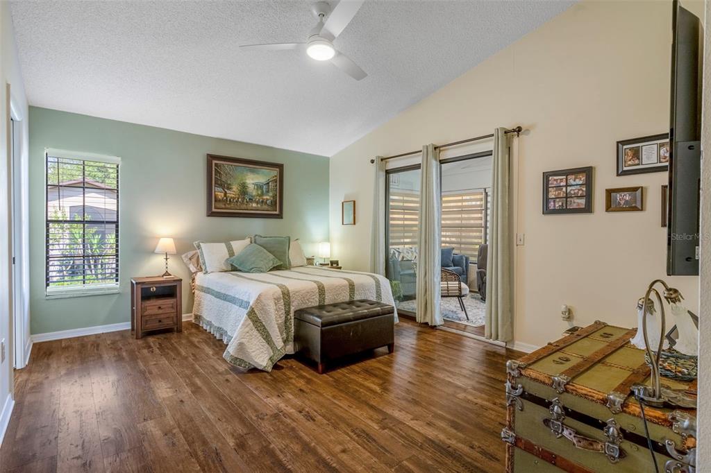 6732 Oak Cluster Circle Spring Hill, FL 34606 - Photo 25 of 65 a spacious bedroom with a bed and wooden floor