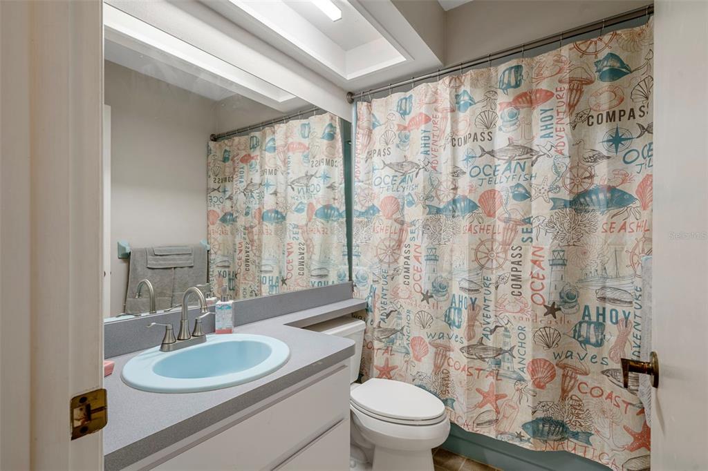 6732 Oak Cluster Circle Spring Hill, FL 34606 - Photo 31 of 65 a bathroom with a granite countertop sink a toilet a mirror a shower curtain and a large mirror