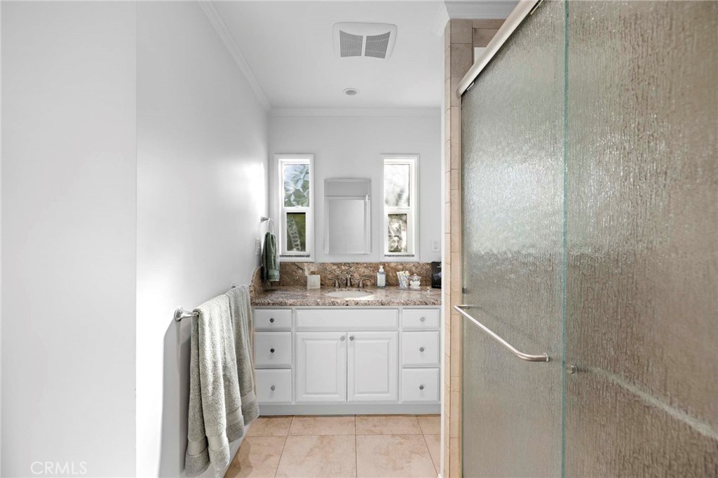 720 East Foothill Boulevard Glendora, CA 91741 - Photo 21 of 37 a bathroom with a granite countertop sink a mirror and a shower