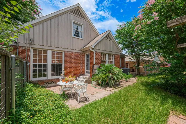 a view of a chair and table in backyard of the house