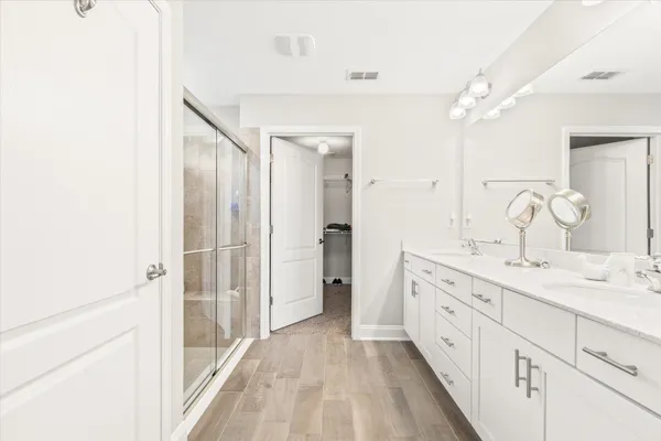 a bathroom with a double vanity sink and mirror with shower
