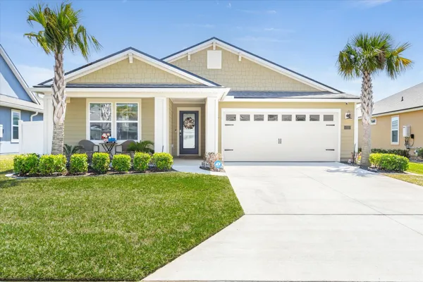 a front view of a house with a garden and yard