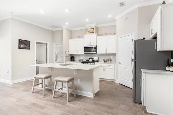 a kitchen with white cabinets and stainless steel appliances