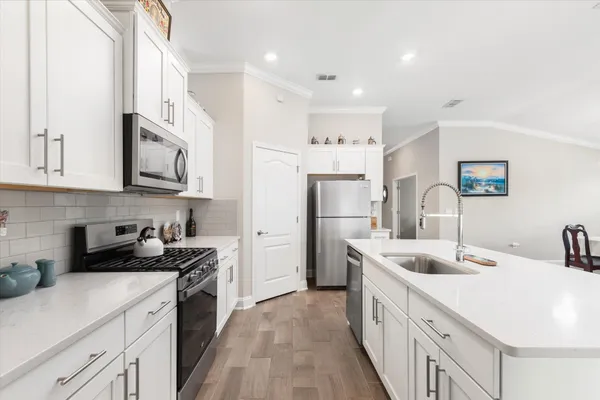 a large white kitchen with stainless steel appliances
