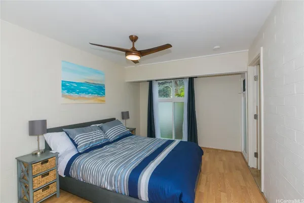 a bedroom with a large bed and a ceiling fan