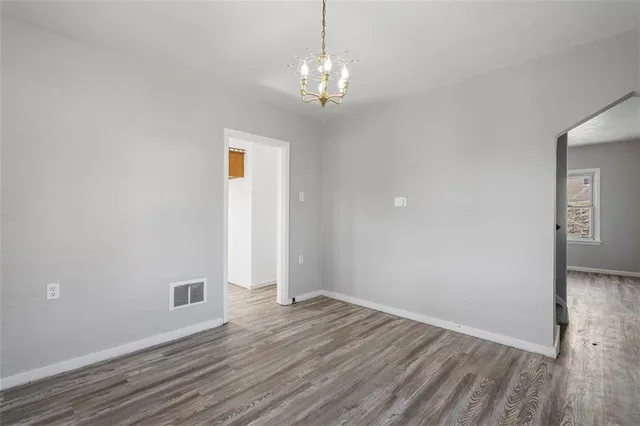 a view of a livingroom with wooden floor and a chandelier