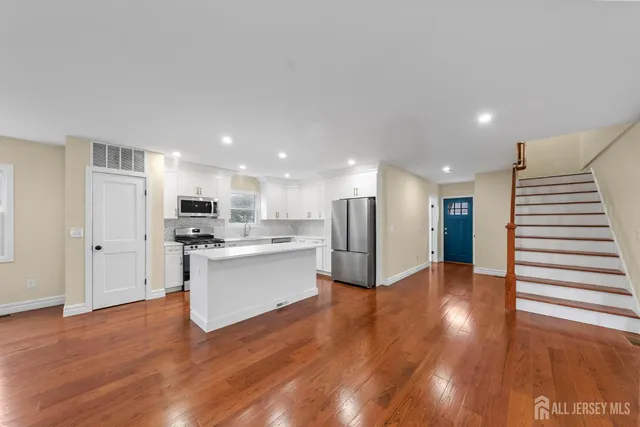 a view of staircase with wooden floor and white walls