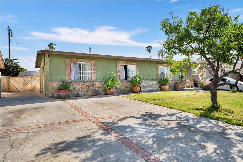 a front view of a house with garden and plants