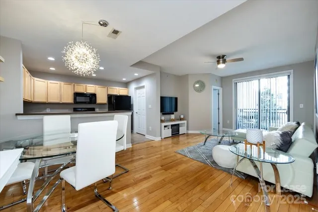 a living room with furniture a dining table and a chandelier