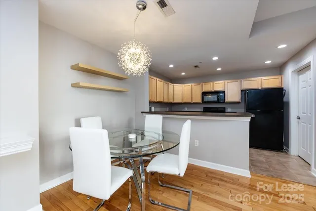 a view of a dining room with furniture a chandelier and wooden floor