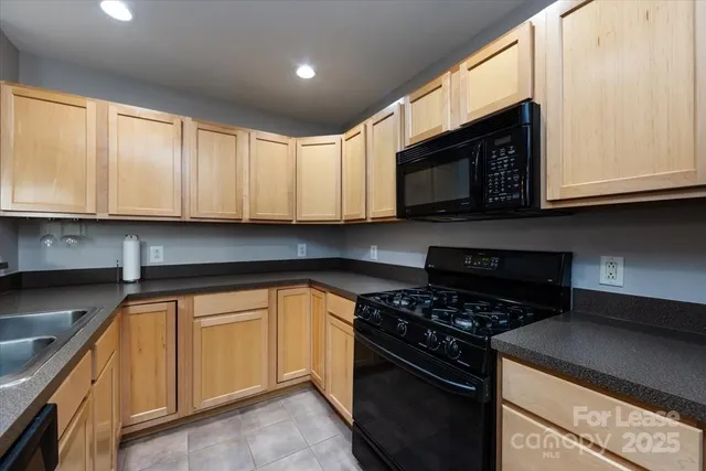 a kitchen with granite countertop cabinets stainless steel appliances and a window