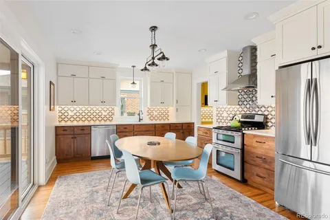 a kitchen with a refrigerator a stove a sink dishwasher and white cabinets with wooden floor