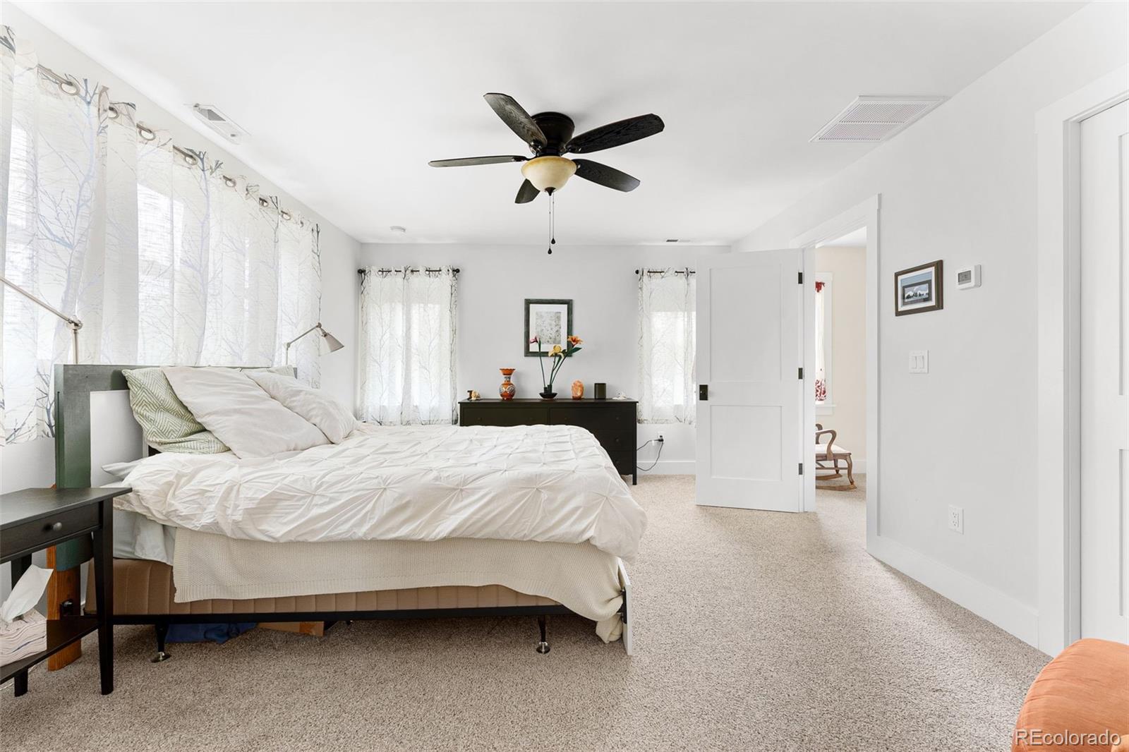 1959 South Washington Street Denver, CO 80210 - Photo 28 of 50 a spacious bedroom with a bed and ceiling fan