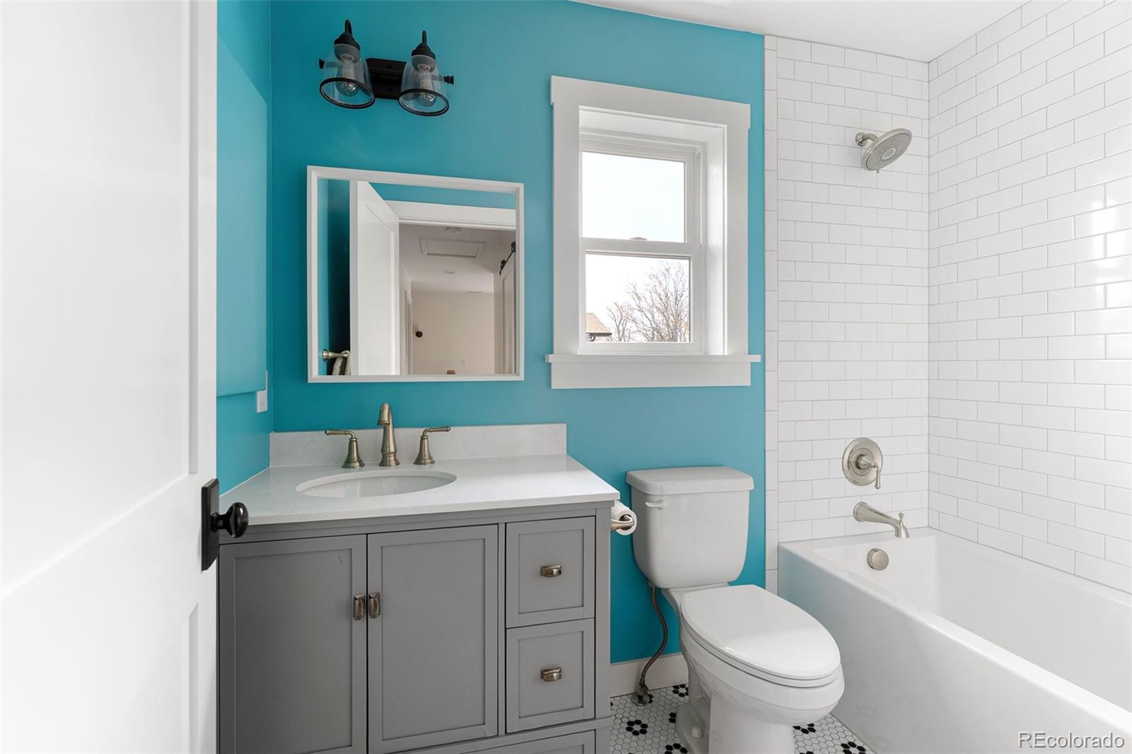 1959 South Washington Street Denver, CO 80210 - Photo 32 of 50 a bathroom with a toilet a sink a mirror and a bathtub