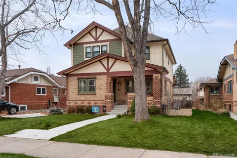a front view of a house with a garden and trees