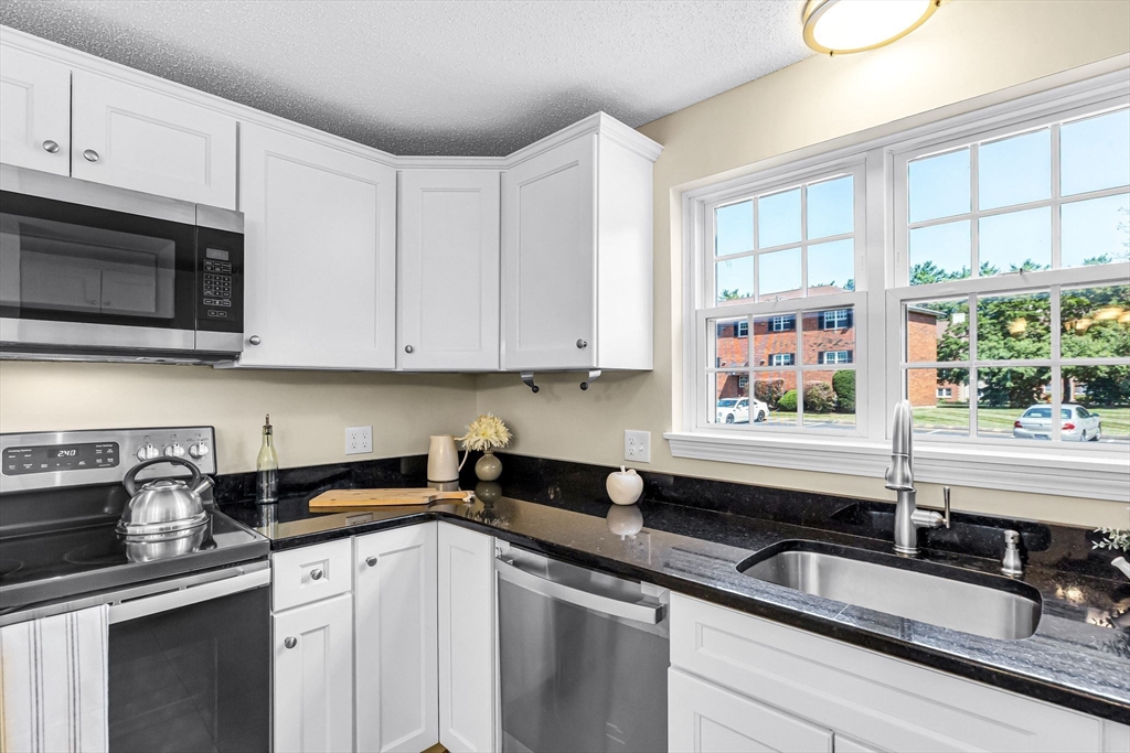 33 Maple Crest Circle, Unit D Holyoke, MA 01040 - Photo 1 of 28 a kitchen with granite countertop a sink a stove and cabinets