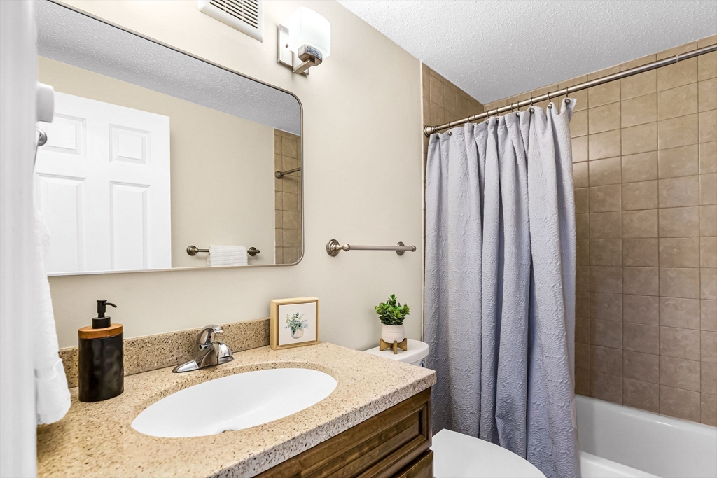 33 Maple Crest Circle, Unit D Holyoke, MA 01040 - Photo 13 of 28 a bathroom with a granite countertop sink a toilet and shower