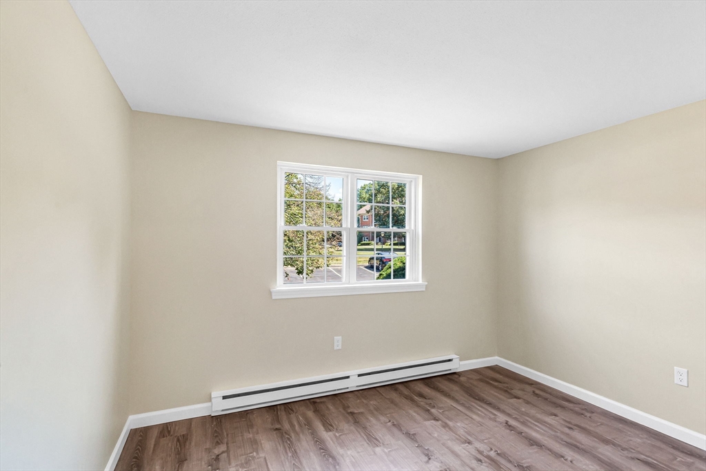 33 Maple Crest Circle, Unit D Holyoke, MA 01040 - Photo 20 of 28 an empty room with wooden floor and windows