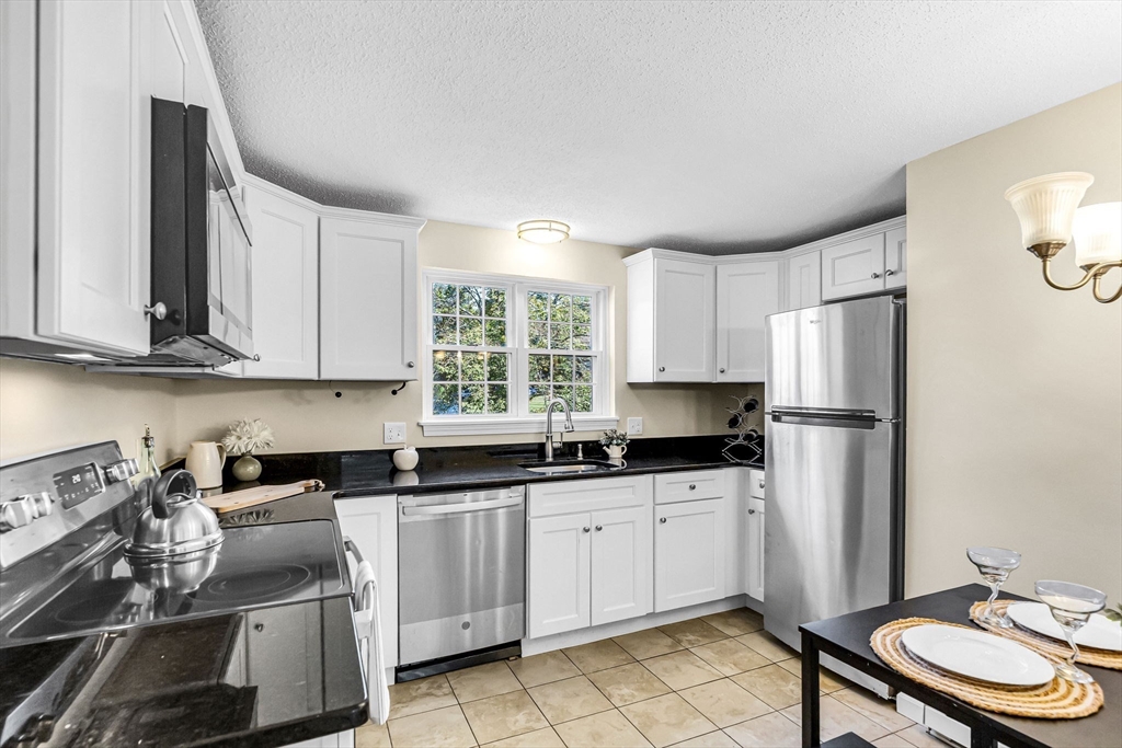 33 Maple Crest Circle, Unit D Holyoke, MA 01040 - Photo 2 of 28 a kitchen with stainless steel appliances a sink a stove a refrigerator and cabinets