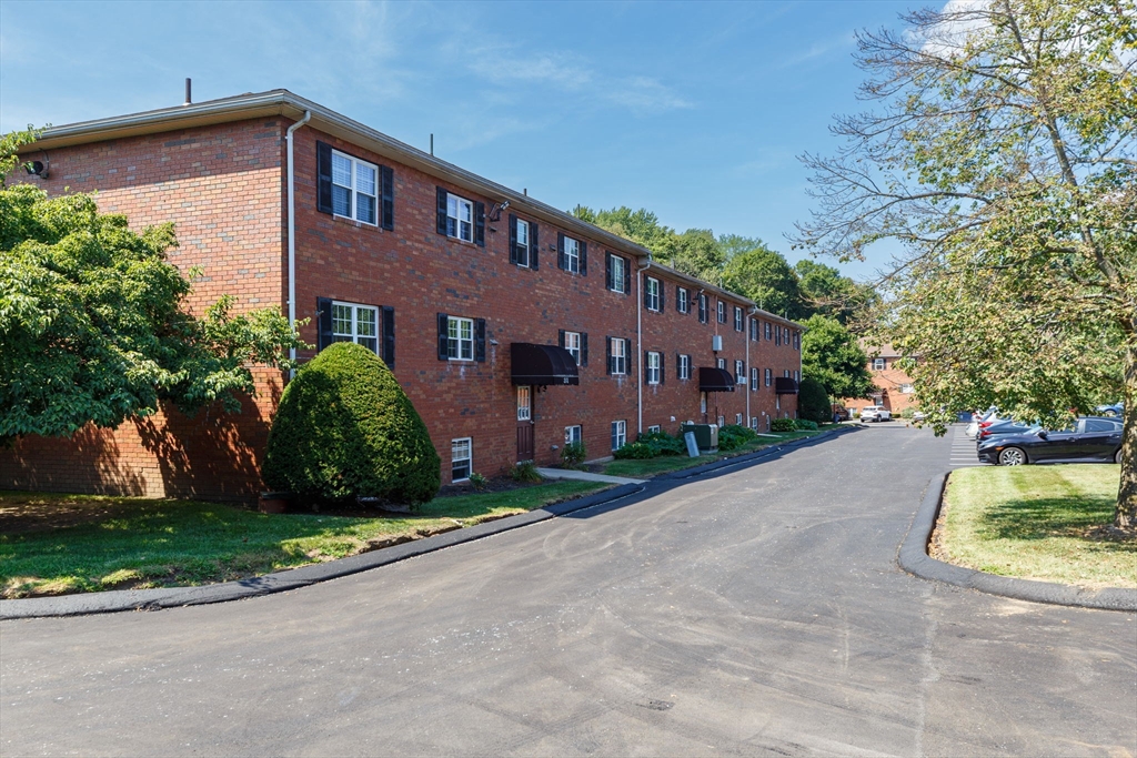 33 Maple Crest Circle, Unit D Holyoke, MA 01040 - Photo 28 of 28 a view of a brick building next to a yard
