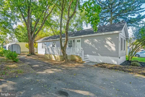 a view of a house with a yard and large tree