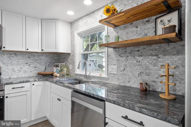 a kitchen with stainless steel appliances granite countertop a sink a stove and cabinets
