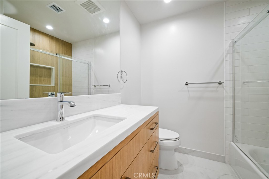 11431 De Celis Place Granada Hills, CA 91344 - Photo 19 of 20 a bathroom with a sink a toilet and a large mirror