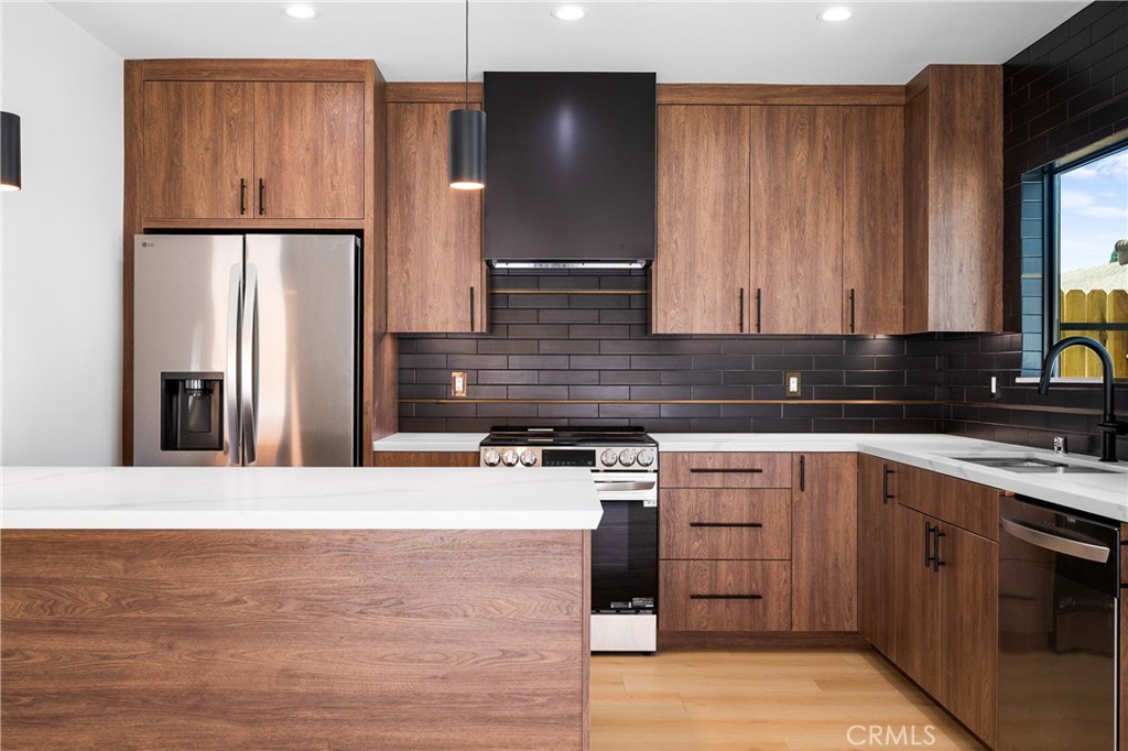 11431 De Celis Place Granada Hills, CA 91344 - Photo 7 of 20 a kitchen with stainless steel appliances granite countertop a refrigerator sink and cabinets