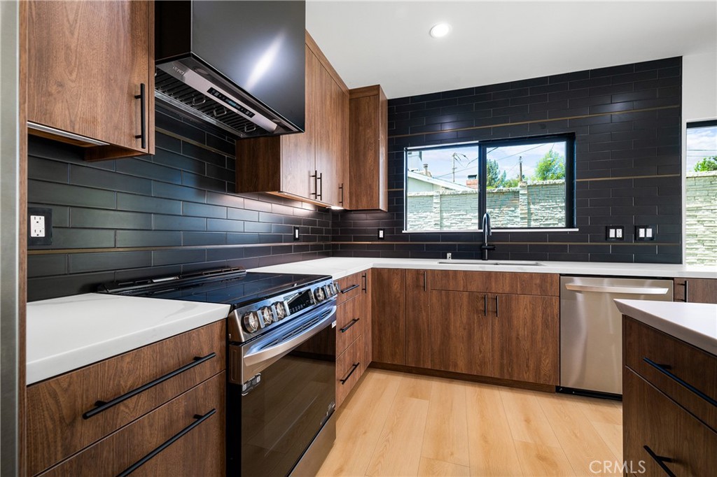 11431 De Celis Place Granada Hills, CA 91344 - Photo 8 of 20 a kitchen with granite countertop a stove and a sink