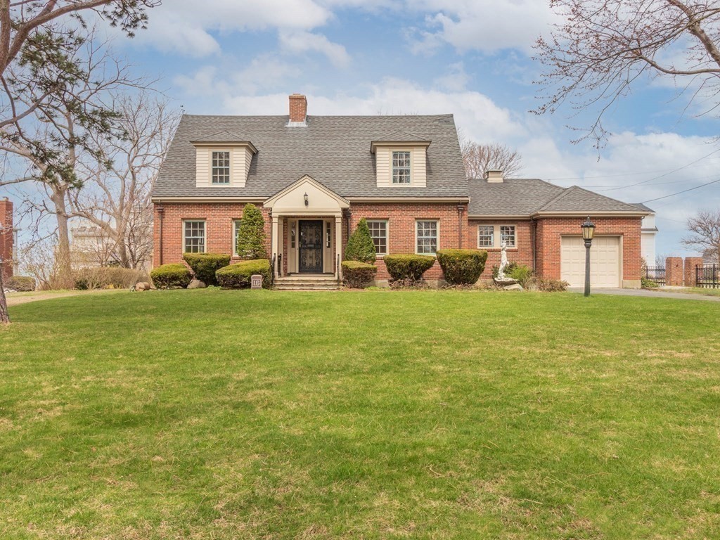 a front view of a house with a big yard and potted plants