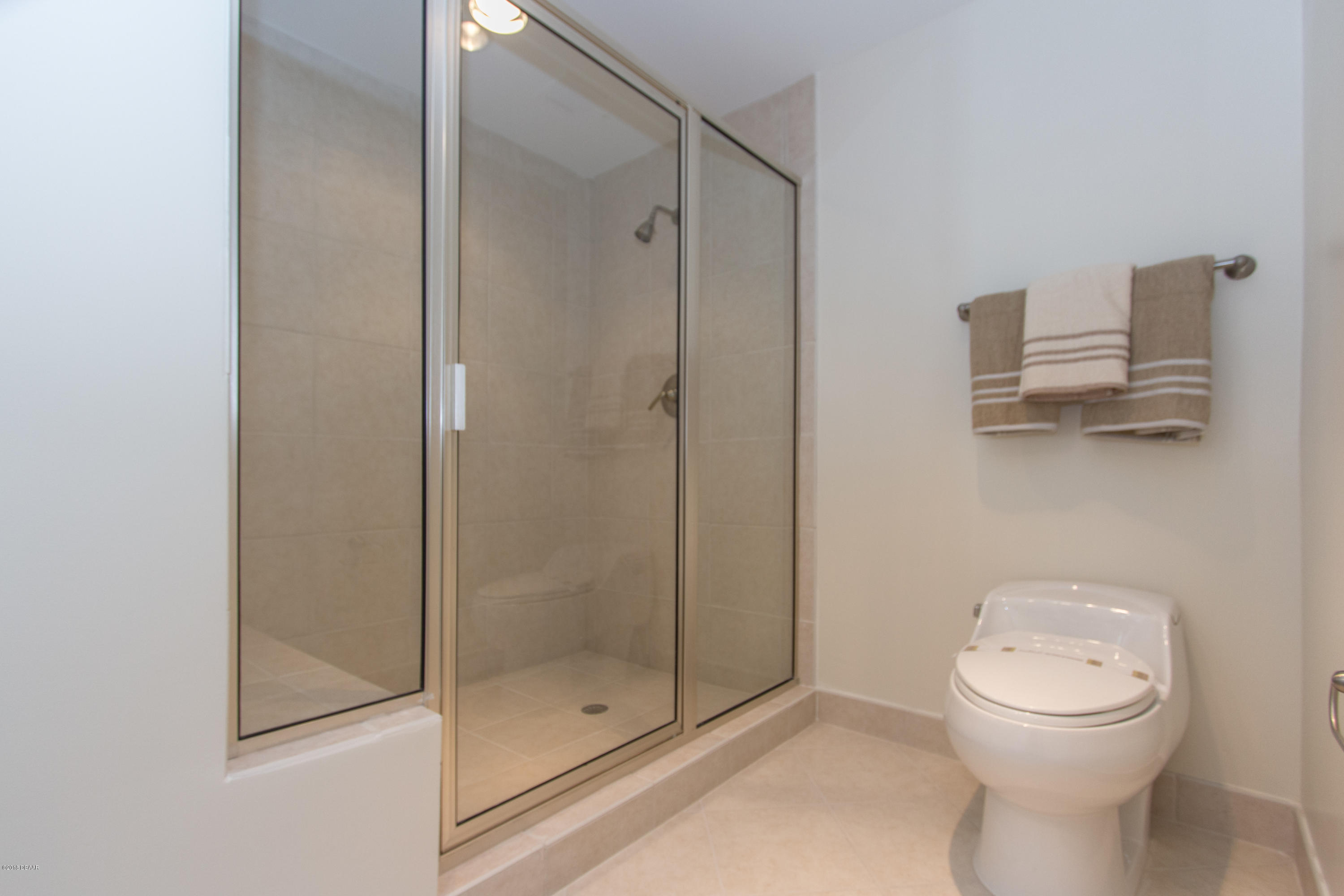 241 Riverside Drive, Unit 1409 Holly Hill, FL 32117 - Photo 23 of 35 a bathroom with a shower a toilet and a sink