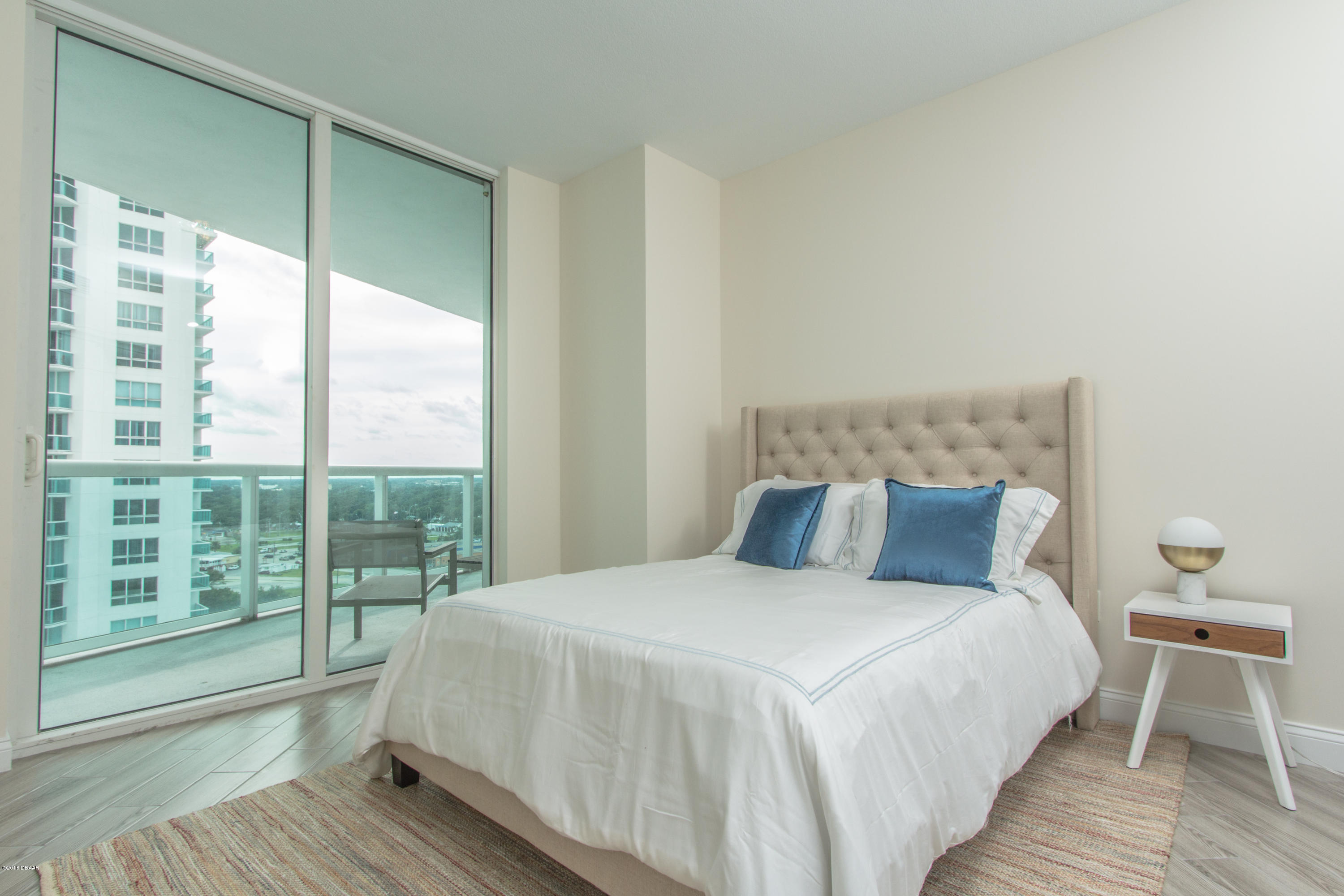 241 Riverside Drive, Unit 1409 Holly Hill, FL 32117 - Photo 25 of 35 a bedroom with a large bed and a large window