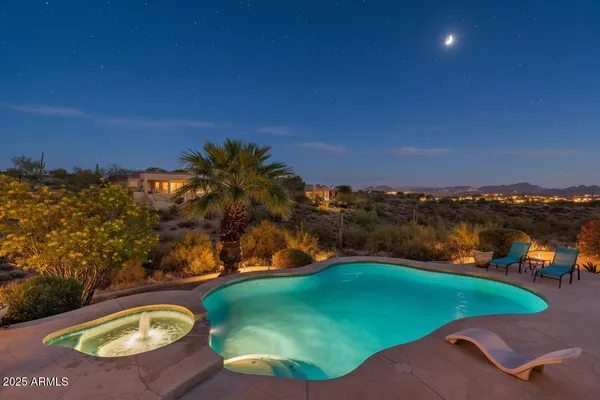 an aerial view of a house with a swimming pool and lake view