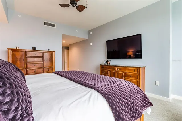 a bedroom with a large bed and a chandelier