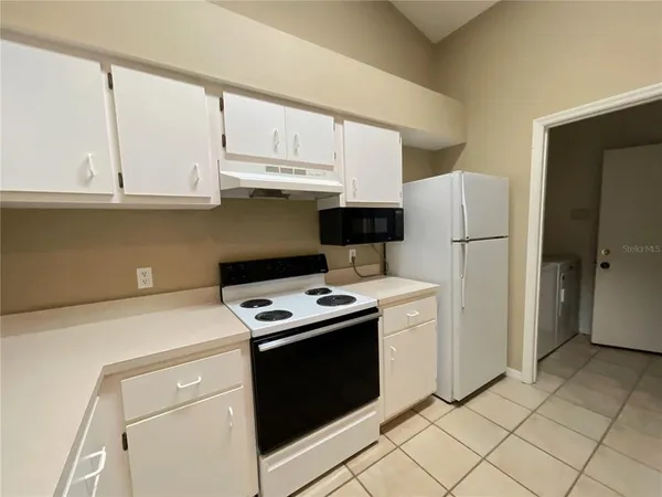 a kitchen with stainless steel appliances white cabinets and a refrigerator