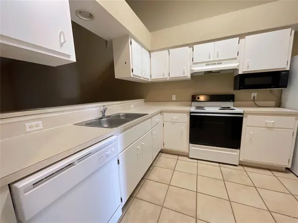 a kitchen with a stove sink and cabinets